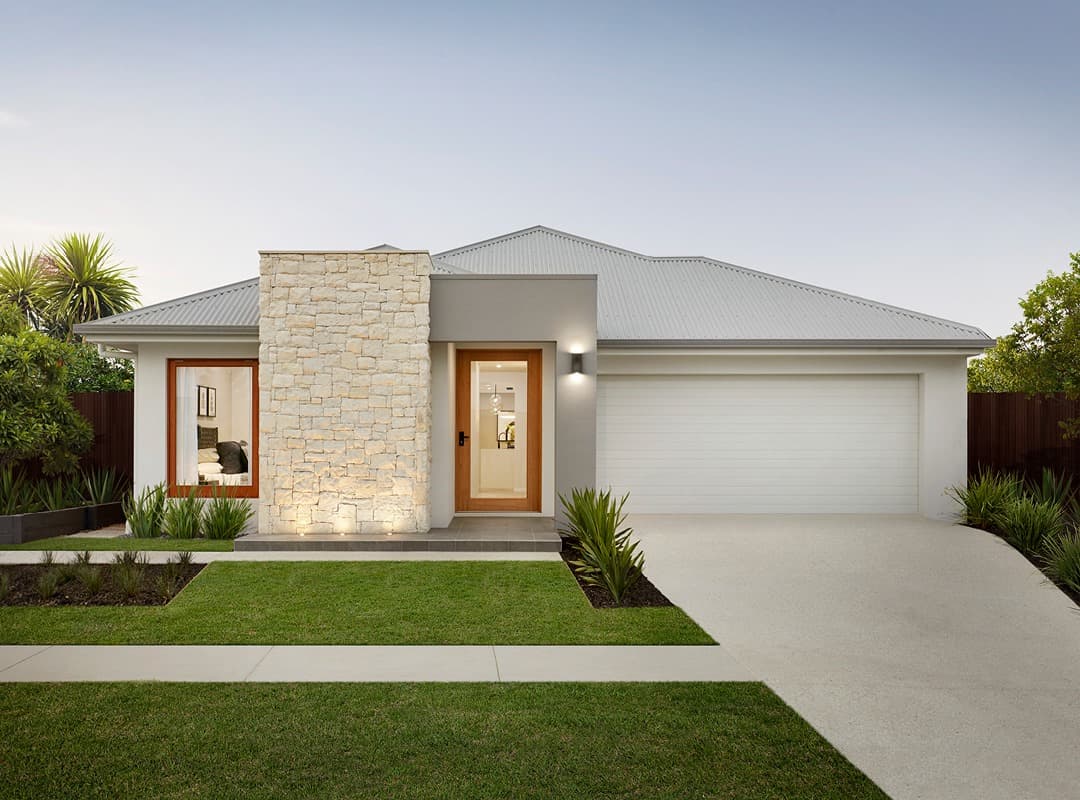 Modern single-story home featuring a stone wall, wooden door, and white double garage.